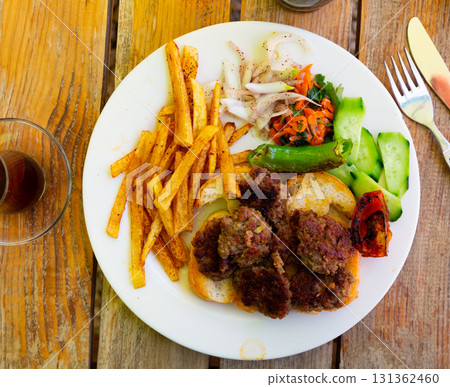 Delicious turkish kofte and French fries on wooden board Delicious turkish kofte and French fries on wooden board 131362460