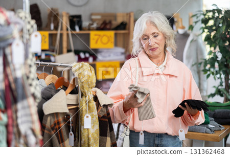 Elderly woman choosing gloves in clothing store 131362468