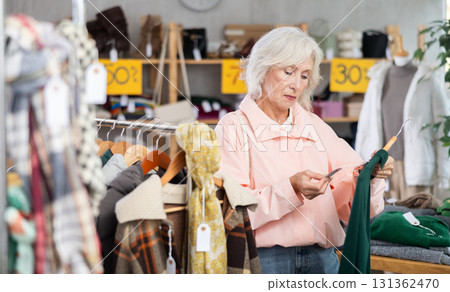 During November sales, mature woman choose and buy warm knitted dress 131362470