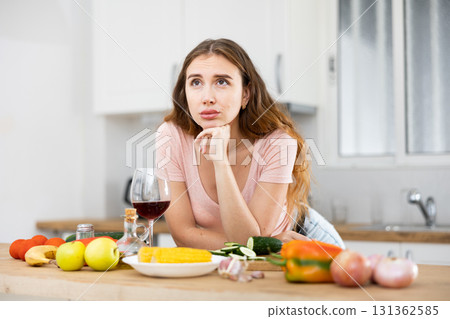 Upset woman texting on mobile phone in kitchen 131362585