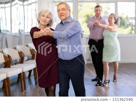 Senior man and elderly woman are dancing classic version of waltz in couple 131362590