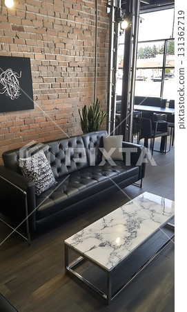 Black couch sits in front of a white marble coffee table 131362719