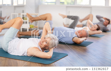 Pensioners doing fitness in group classes - doing exercises for abdominal muscles 131362817