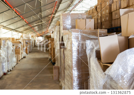 Warehouse - boxes with various goods on racks and on floor 131362875
