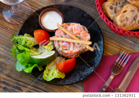 Popular appetizer of French cuisine is salmon tartare with onion cream Popular appetizer of French cuisine is salmon tartare with onion cream 131362931