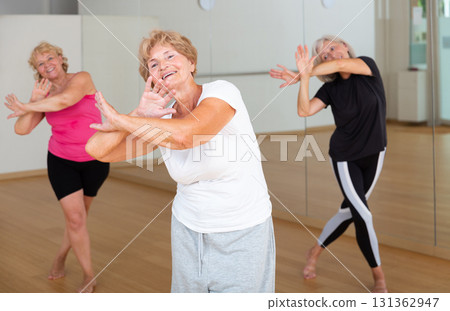 Mature active women practice vigorous swing Mature active women practice vigorous swing 131362947