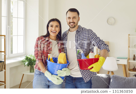 Young happy couple clean, man and woman janitor pair with house cleaning materials Young happy couple clean, man and woman janitor pair with house cleaning materials 131363850
