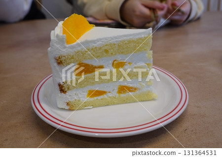 A delectable slice of cake with rich layers of cream and frosting, topped with fresh fruit or sprinkles. Perfect for dessert photography, showcasing indulgence and sweetness in food-related projects. 131364531