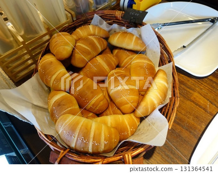 Golden brown salt bread with a soft, fluffy interior and a perfectly crisp crust, lightly sprinkled with coarse salt for a savory touch. A simple yet satisfying treat for any occasion. 131364541