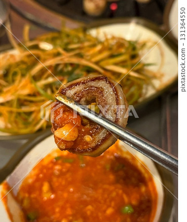 Grilled makchang, Korean beef or pork intestine, cooked to crispy perfection with a smoky, chewy texture. Served with dipping sauces and vegetables for a flavorful and savory experience. 131364550