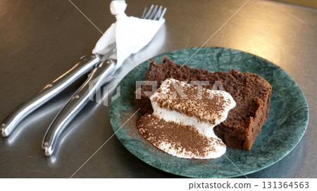 A delectable slice of cake with rich layers of cream and frosting, topped with fresh fruit or sprinkles. Perfect for dessert photography, showcasing indulgence and sweetness in food-related projects. 131364563