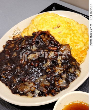 Classic jajangmyeon with thick noodles in a rich black bean sauce, garnished with sliced cucumber and sesame seeds. A beloved Korean-Chinese comfort dish, full of savory depth and flavor. 131364583