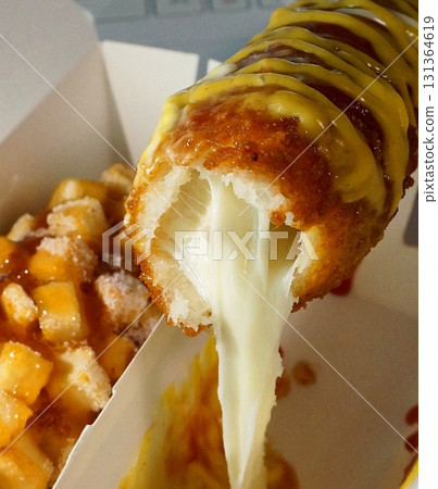 Korean corn dog, a crispy snack coated in a sweet batter, often stuffed with sausage, cheese, or both. Topped with sugar, ketchup, or mustard for a delightful mix of flavors and textures. Korean corn dog, a crispy snack coated in a sweet batter, often stuffed with sausage, cheese, or both. Topped with sugar, ketchup, or mustard for a delightful mix of flavors and textures. 131364619