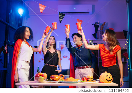 Joyful office Halloween party with coworkers in costumes, celebrating with drinks and laughter, fostering teamwork Joyful office Halloween party with coworkers in costumes, celebrating with drinks and laughter, fostering teamwork 131364795