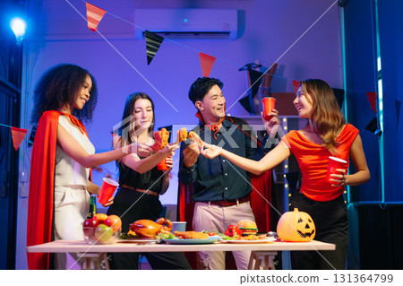 Joyful office Halloween party with coworkers in costumes, celebrating with drinks and laughter, fostering teamwork 131364799