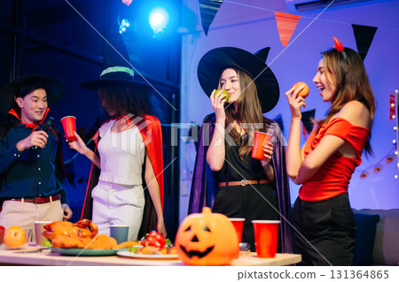 Joyful office Halloween party with coworkers in costumes, celebrating with drinks and laughter, fostering teamwork Joyful office Halloween party with coworkers in costumes, celebrating with drinks and laughter, fostering teamwork 131364865