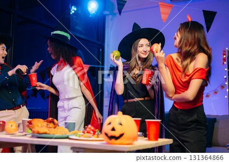Joyful office Halloween party with coworkers in costumes, celebrating with drinks and laughter, fostering teamwork Joyful office Halloween party with coworkers in costumes, celebrating with drinks and laughter, fostering teamwork 131364866