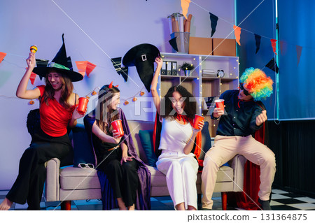 Joyful office Halloween party with coworkers in costumes, celebrating with drinks and laughter, fostering teamwork Joyful office Halloween party with coworkers in costumes, celebrating with drinks and laughter, fostering teamwork 131364875