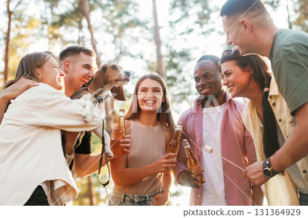 With dog. Group of friends are having fun together in the forest With dog. Group of friends are having fun together in the forest 131364929