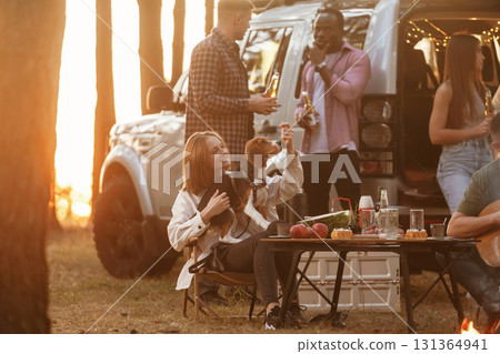 By the campfire. Group of friends are having fun together in the forest 131364941