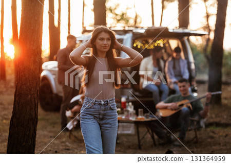 Gorgeous woman is standing and enjoying nature. Group of friends are having fun together in the forest 131364959