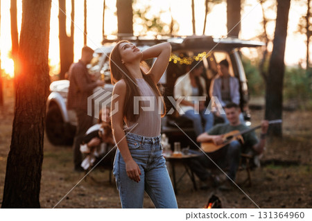 Pretty woman is standing and enjoying nature. Group of friends are having fun together in the forest 131364960