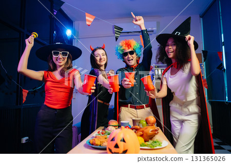 Joyful office Halloween party with coworkers in costumes, celebrating with drinks and laughter, fostering teamwork Joyful office Halloween party with coworkers in costumes, celebrating with drinks and laughter, fostering teamwork 131365026