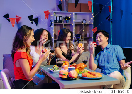Celebration with friends enjoying food, drinks, and laughter at a lively house party. Celebration with friends enjoying food, drinks, and laughter at a lively house party. 131365028