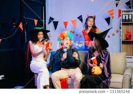 Joyful office Halloween party with coworkers in costumes, celebrating 131365248