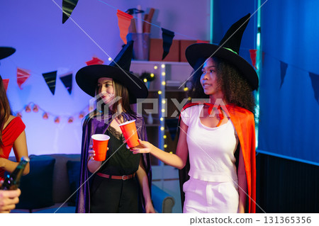 Joyful office Halloween party with coworkers in costumes, celebrating with drinks and laughter, fostering teamwork Joyful office Halloween party with coworkers in costumes, celebrating with drinks and laughter, fostering teamwork 131365356