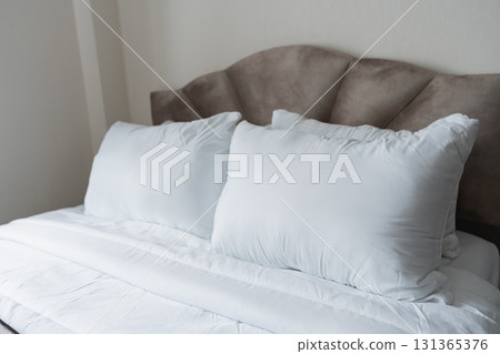 Cozy and Comfortable Bed with Soft White Pillows and Smooth Blanket in a Calm Bedroom Setting for Relaxation and Restful Sleep 131365376