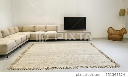 Living room with a white couch, a black television, and a wicker chair 131365824