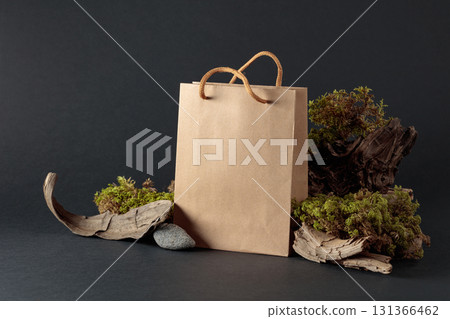 Paper bag with snags, stones, and moss on a black background. 131366462