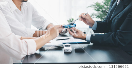 Panorama view of car loan agreement signing with dealer presenting vehicle model, customer using calculator at office desk, concept of auto finance, leasing, insurance and business contract. 131366631