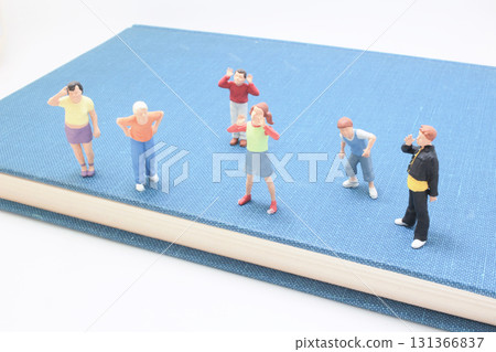 Group of Tiny Figurines Standing on a Blue Book Surface, Group of Tiny Figurines Standing on a Blue Book Surface, 131366837