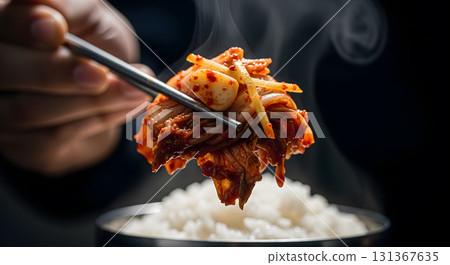 Closeup of kimchi on chopsticks with rice and steam. Closeup of kimchi on chopsticks with rice and steam. 131367635