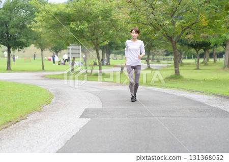 Two women running in the park 131368052