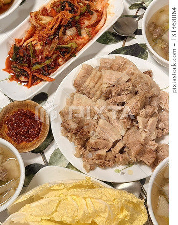 Suyuk, a traditional Korean dish of boiled pork slices, tender and juicy, often served with salted shrimp sauce, garlic, and ssamjang. Perfect for wrapping in lettuce for a flavorful, balanced bite. 131368064