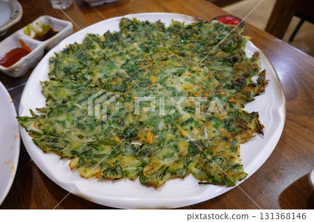Crispy and savory Korean Pajeon, or scallion pancake, made with green onions and a variety of vegetables. A delicious, traditional Korean snack perfect for any meal. Crispy and savory Korean Pajeon, or scallion pancake, made with green onions and a variety of vegetables. A delicious, traditional Korean snack perfect for any meal. 131368146