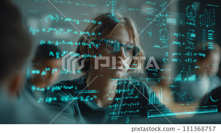 Young student wearing glasses focused on complex mathematical formulas and graphs on transparent screen in classroom 131368757