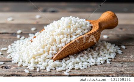 White rice grain wooden scoop rustic table closeup natural food ingredient healthy cooking White rice grain wooden scoop rustic table closeup natural food ingredient healthy cooking 131369151