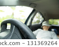 A man taking a nap in the driver's seat 131369264