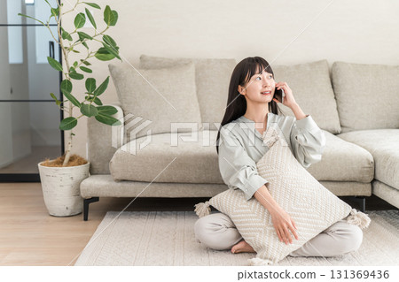 日本女人打電話用智慧型手機（家裡，客廳，微笑） 131369436