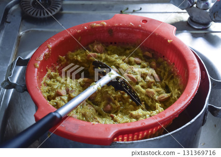 Plastic pot of plum jam. Stirring plum jam 131369716