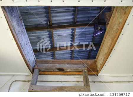 Open the entrance to the attic. The staircase and the door to the attic of the house 131369717