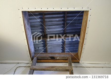 Open the entrance to the attic. The staircase and the door to the attic of the house 131369718