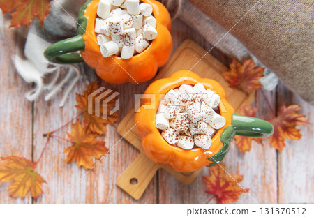 Pumpkin mugs filled with hot chocolate warming up for fall Pumpkin mugs filled with hot chocolate warming up for fall 131370512