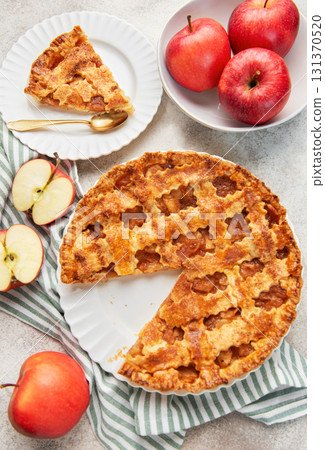 Homemade apple pie with a slice and fresh apples 131370520