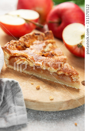Apple pie slice on wooden board with apples 131370522
