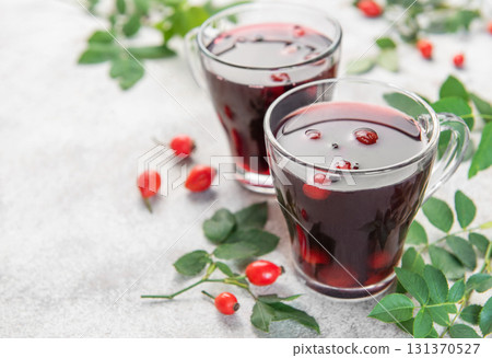 Drinking hot rosehip tea with berries and leaves Drinking hot rosehip tea with berries and leaves 131370527